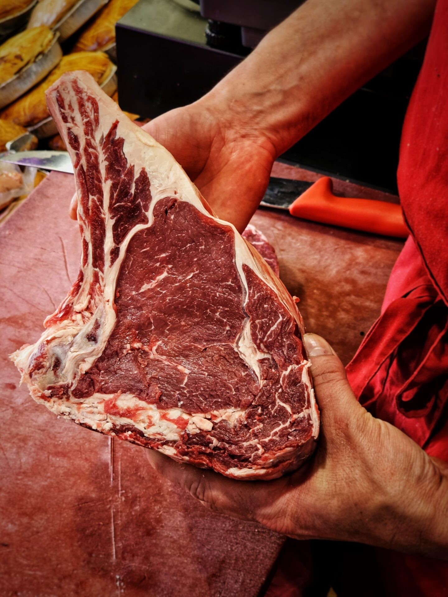 le boucher tient en main une belle cote de boeuf charolais