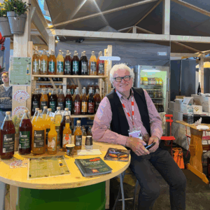 antoine sur un salon présentant ses jus