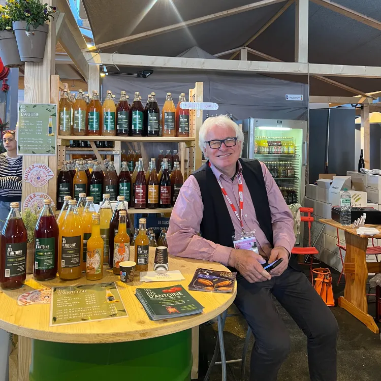 antoine sur un salon présentant ses jus