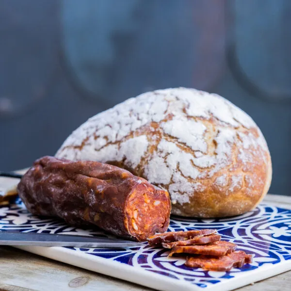 chorizo de sanglier avec tranche et pain sur une faïence