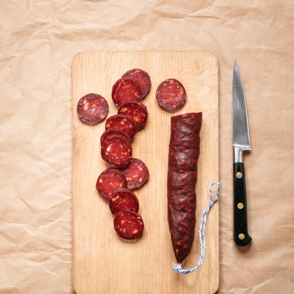 chorizo de canard tranché sur planche avec couteau