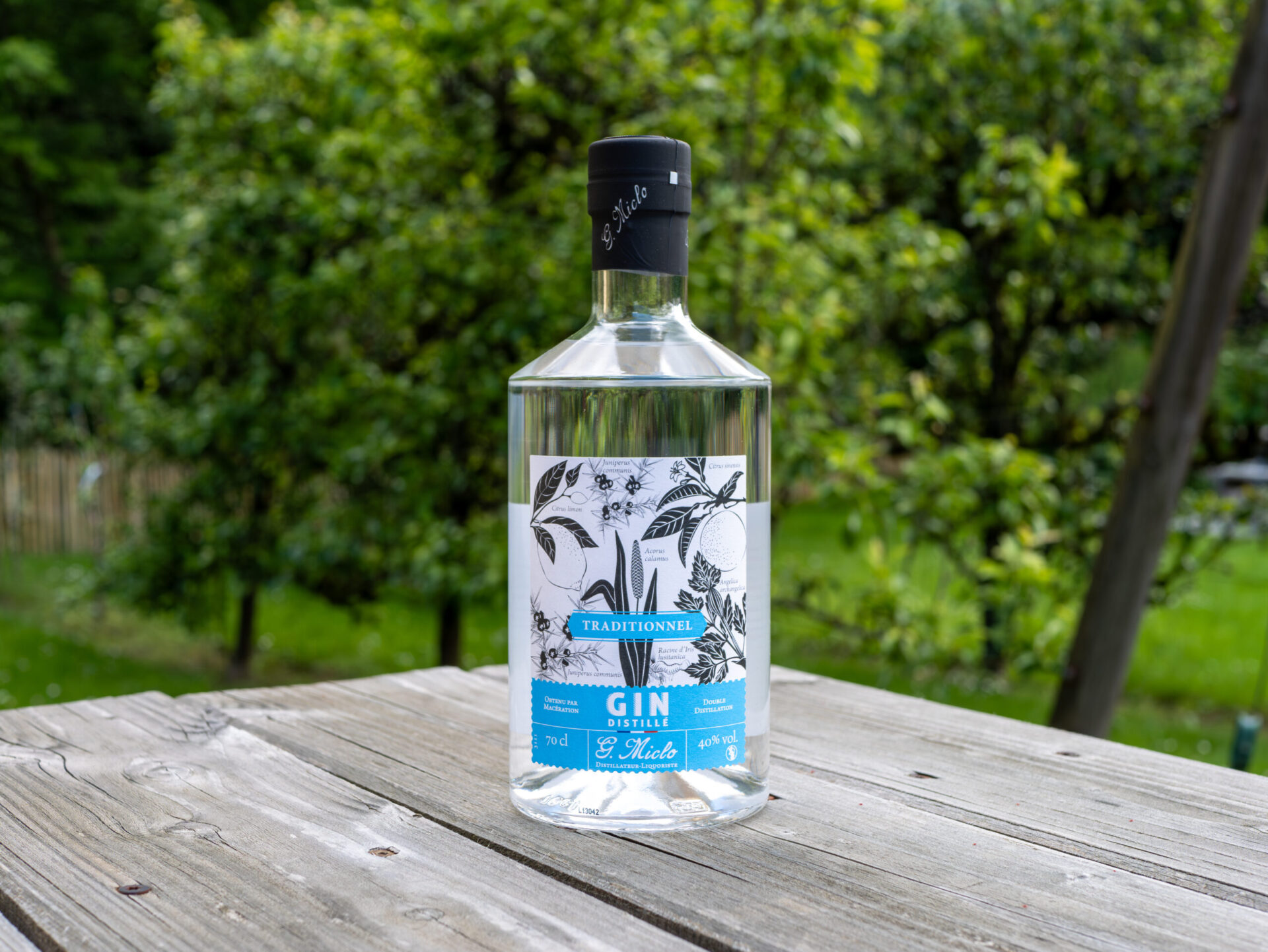 bouteille de gin d'alsace traditionnel posé sur une table en bois