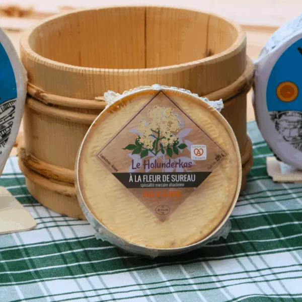 munster holunderkass fleur de sureau devant un pot en bois de crème