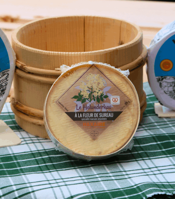 munster holunderkass fleur de sureau devant un pot en bois de crème