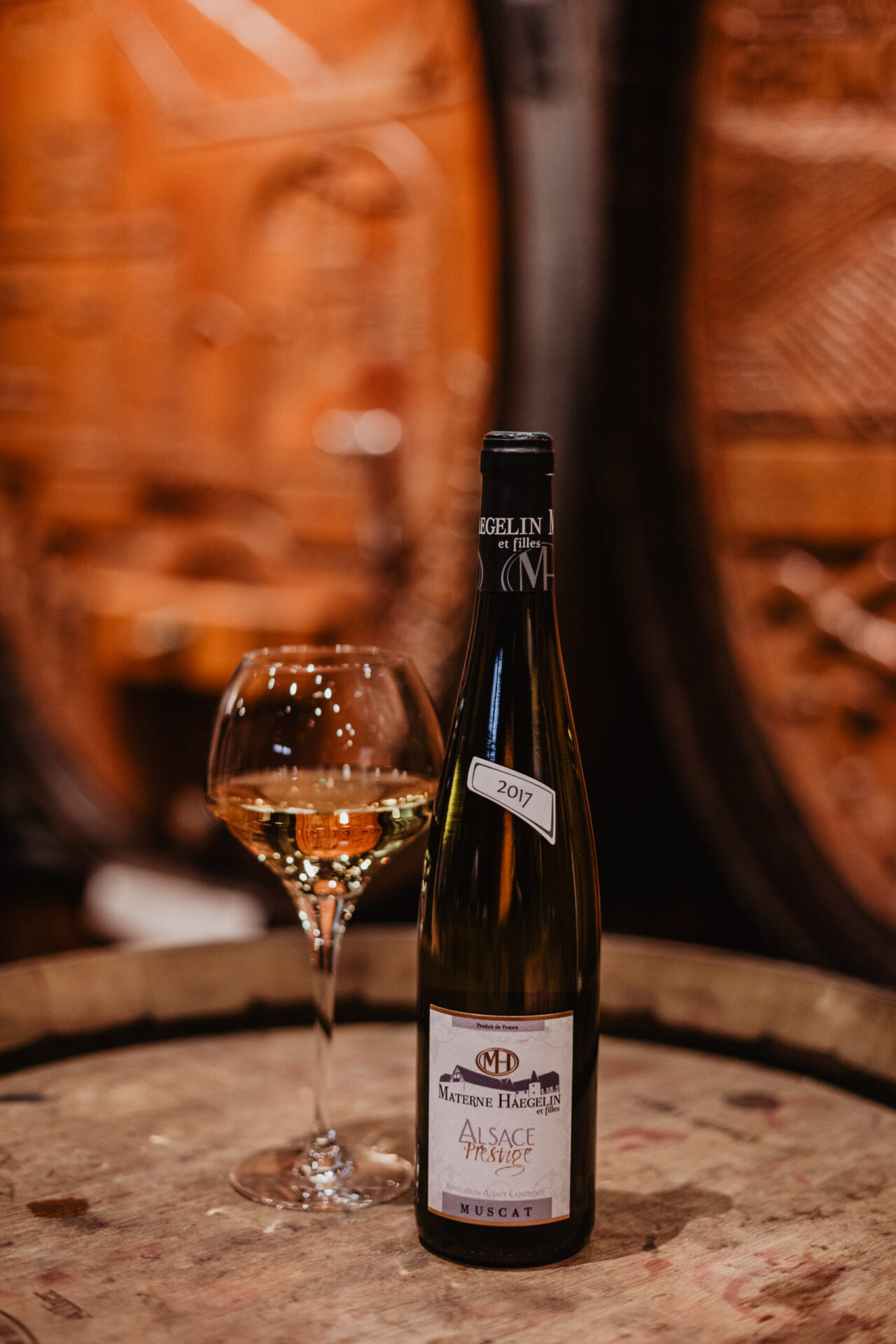 bouteille et verre de muscat d'alsace dans la cave du domaine materne haegelin