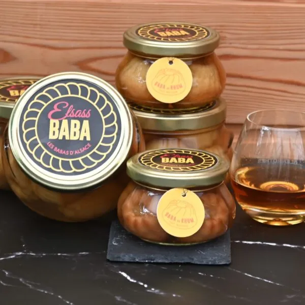 plusieurs pots empilés de babas au rhum avec verre de rhum
