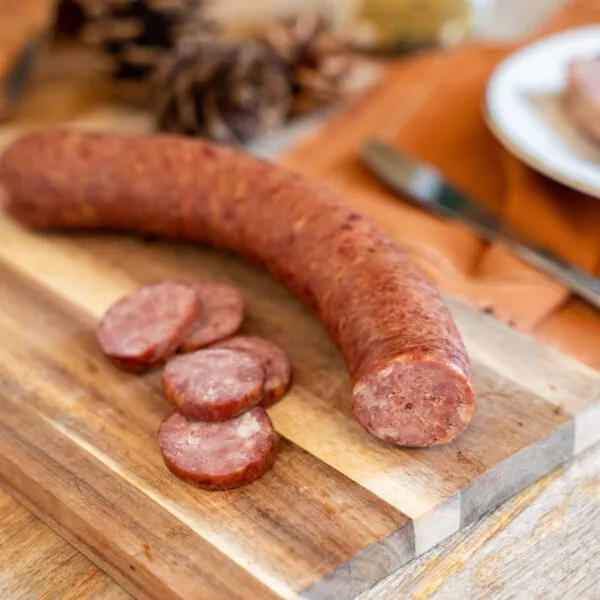 saucisson fumé de sanglier sur planche en bois et rondelles