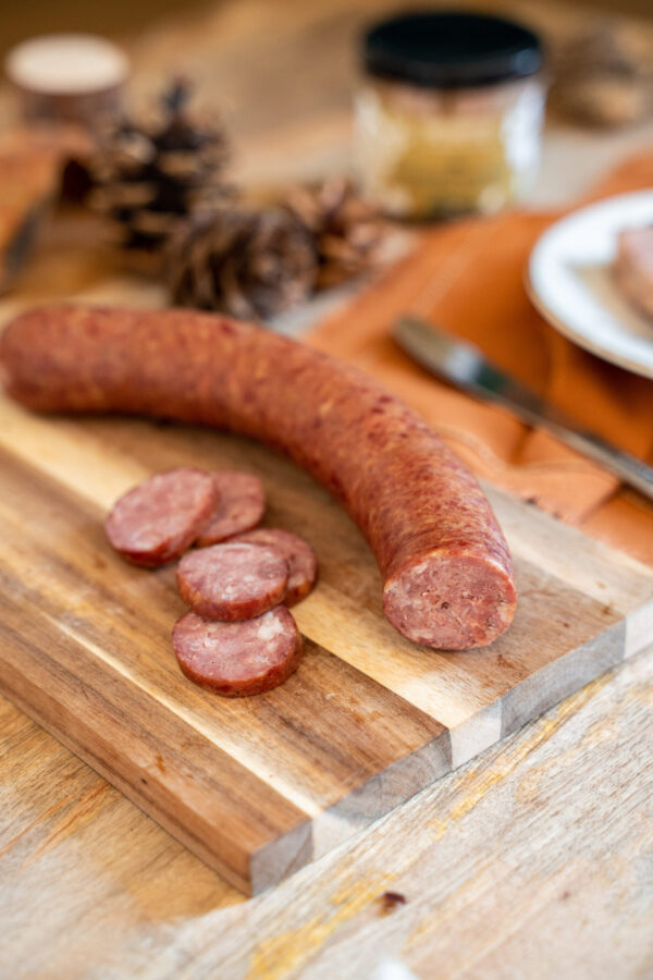 saucisson fumé de sanglier sur planche en bois et rondelles