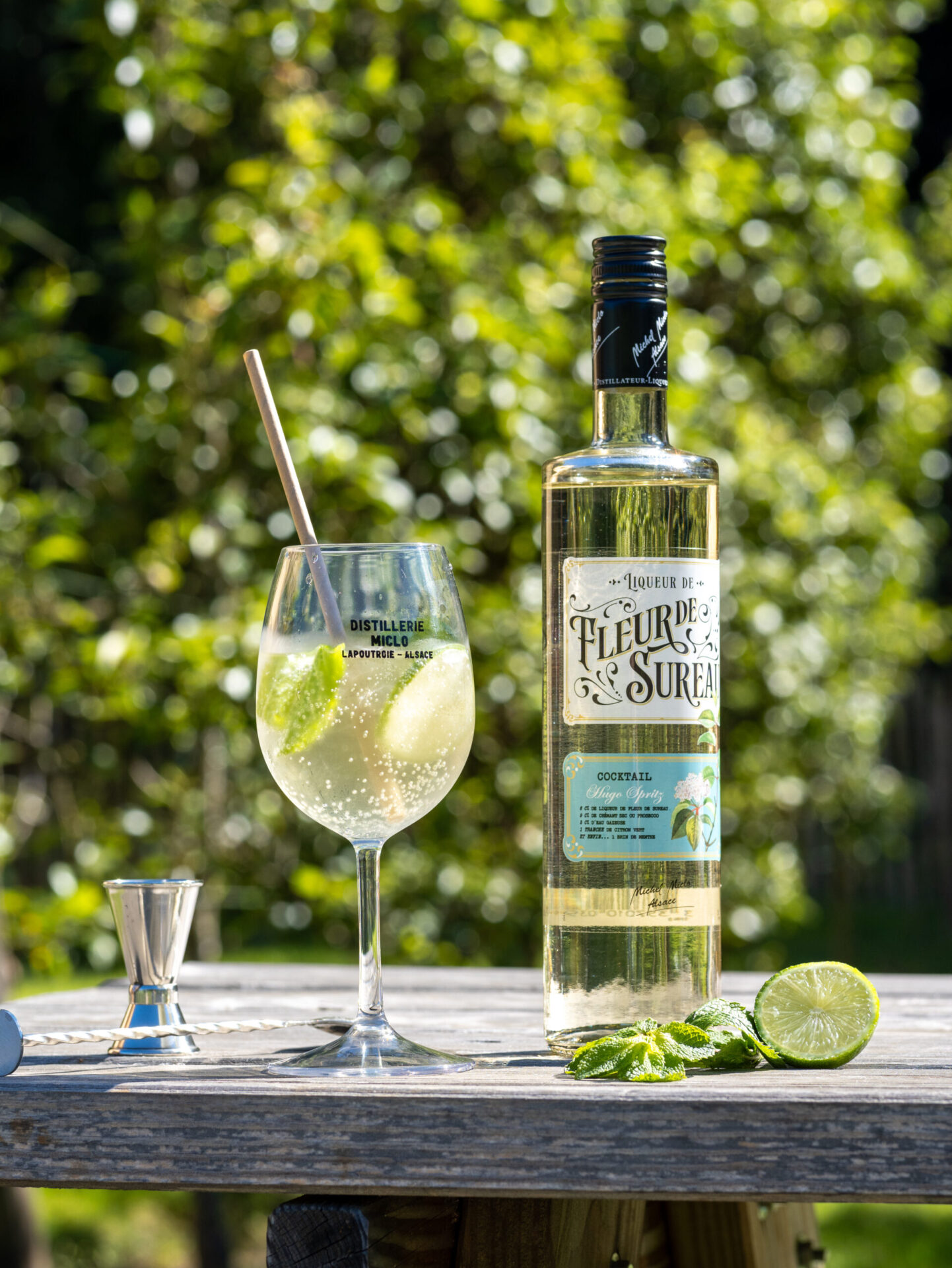 bouteille de liqueur de fleur de sureau et verre avec cocktail hugo