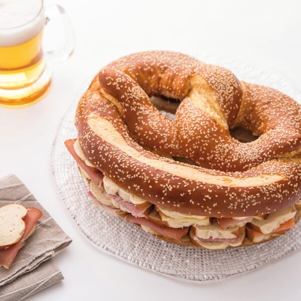 bretzel garni à coté d'une bière