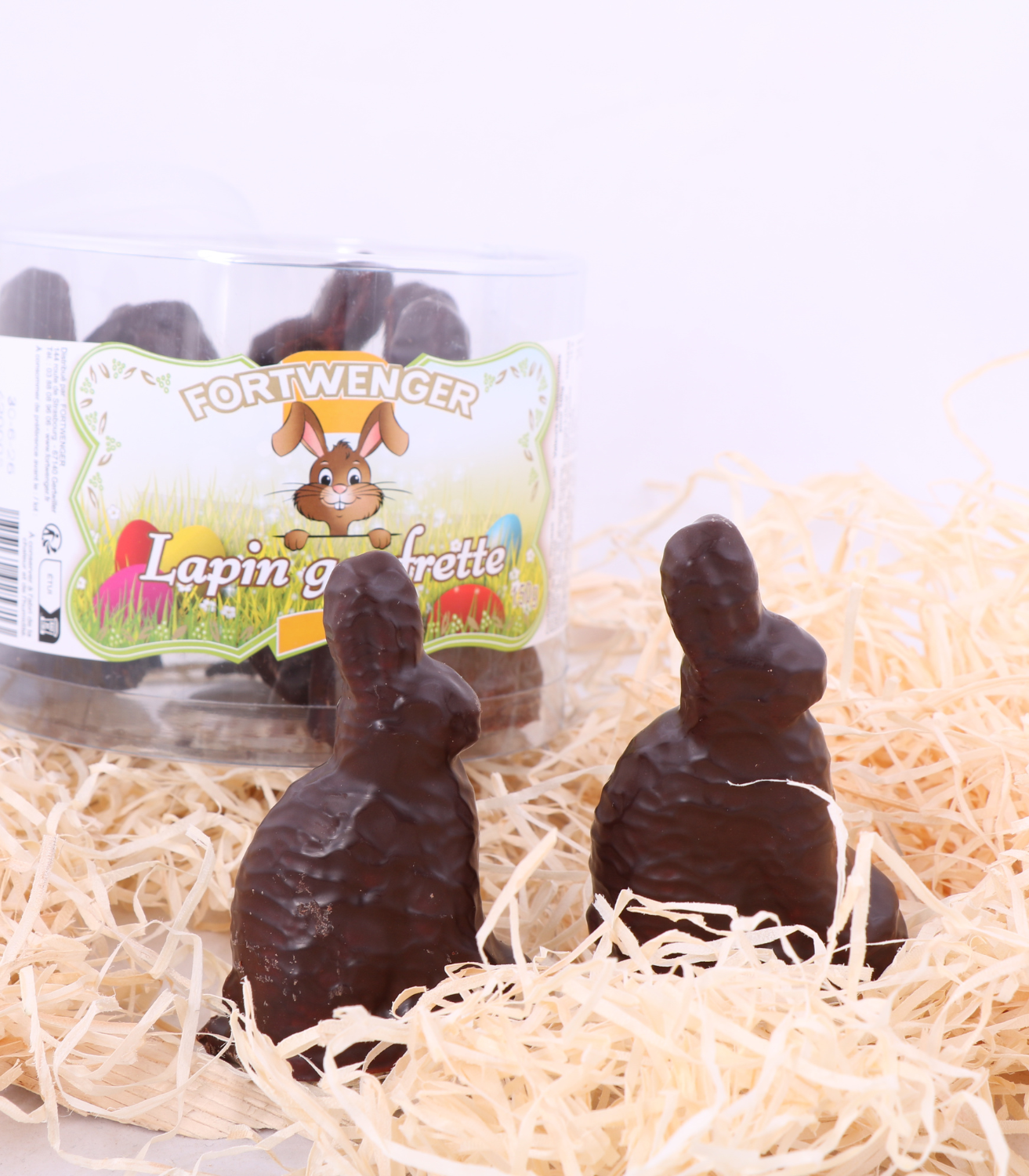 2 lapins en chocolat noir sur de la paille