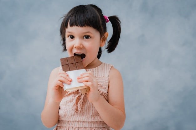 une enfant mangeant une tablette de chocolat 