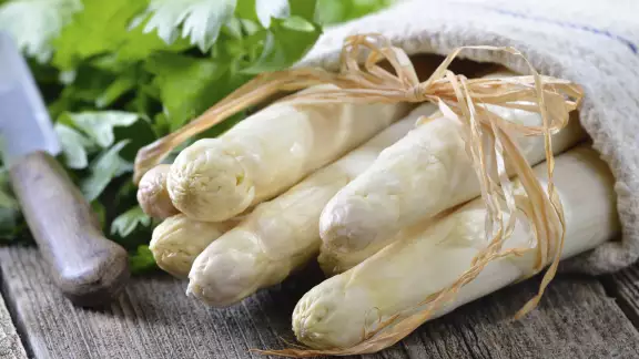 Asperges blanches d'alsace sur une planche avec couteau